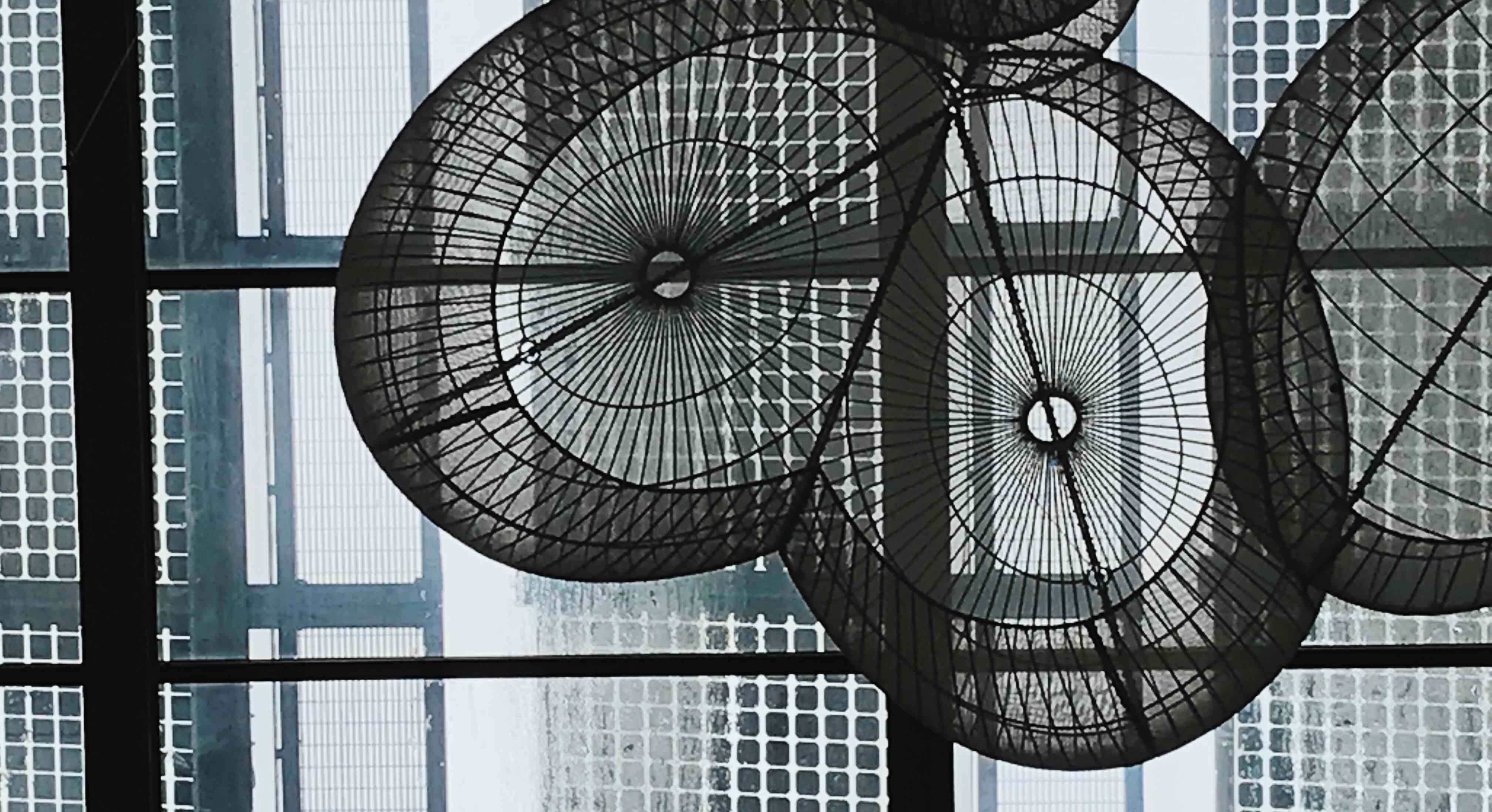 Grid texture on a ceiling with thin, radial sculpture fanning outward.